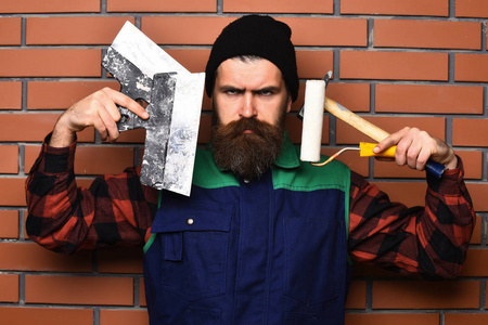 大胡子的画家男子手持各种建筑工具与严肃的面孔