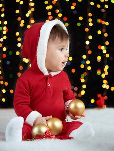 圣诞装饰，打扮成圣诞老人，博克灯在黑暗的背景下，冬天假日概念的婴儿照