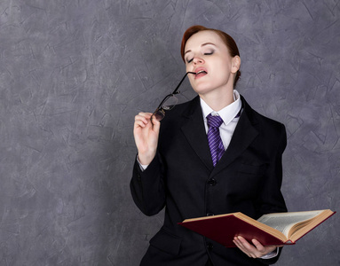 律师助理女律师拿着严肃的表情,女人在大书勒芒西装, 领带, 眼镜等