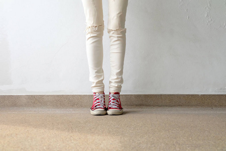 从女人穿着红色运动鞋上混凝土楼板背景的特写照片