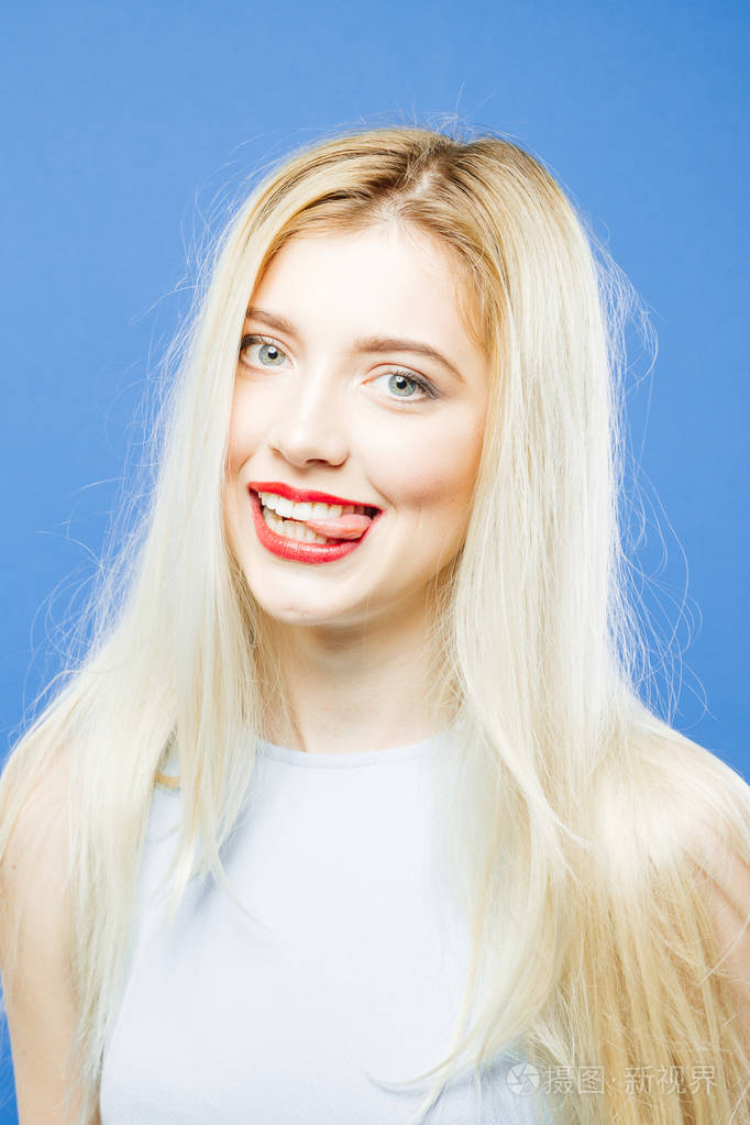 在蓝色背景上的露齿微笑的可爱女人.
