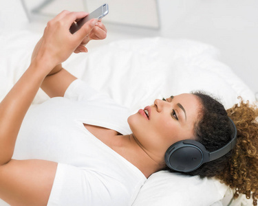 女人听音乐和看着智能手机与担忧的表情
