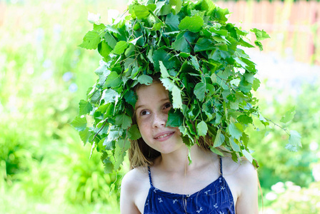 漂亮的小女孩，用绿色的树叶的花环