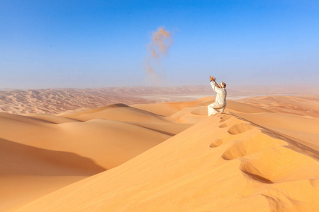 在当地的传统服装，玩沙子空气利瓦沙漠中的阿拉伯男人