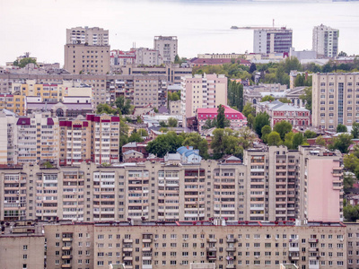 从山上看萨拉托夫市的景色。城市景观基础设施公寓房屋公共建筑和街道, 地平线上的伏尔加河。俄罗斯省