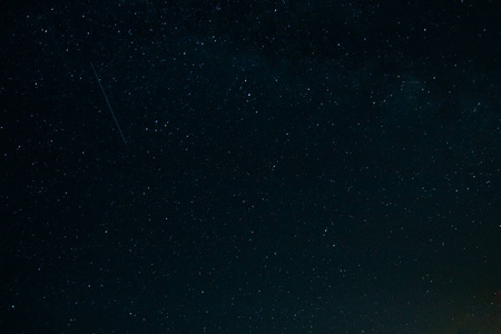 下一颗流星在夜空中与星星照片