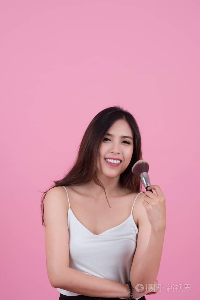 美亚洲女孩棕褐色皮肤与化妆刷子她微笑着和