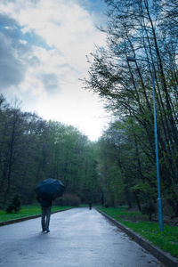 男人在雨天走过公园