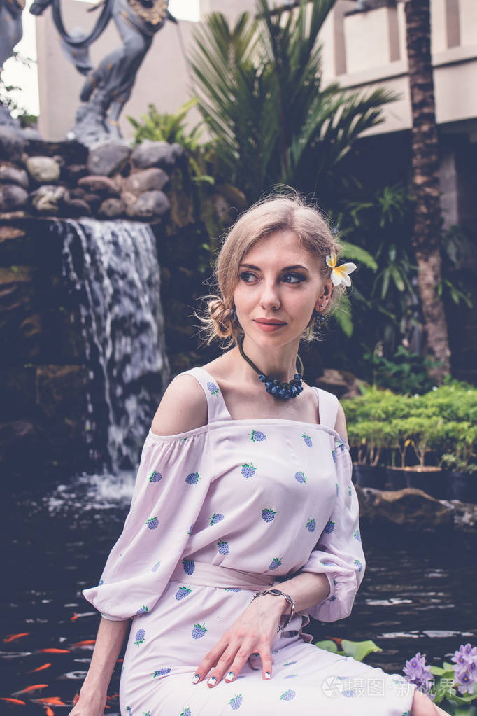 在热带花园的巴厘岛印度尼西亚构成在背景上的花园瀑布性感的年轻女性