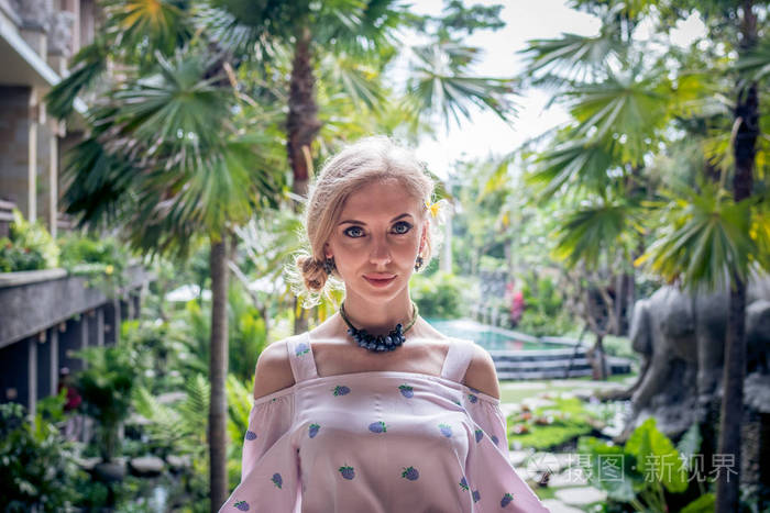 女人摆在热带花园的巴厘岛印度尼西亚
