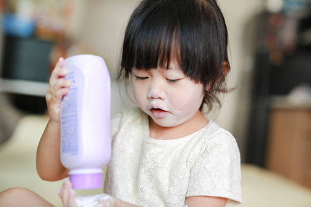 可爱的小女孩，她脸上的婴儿奶粉的画像。小女孩倒向手滑石粉