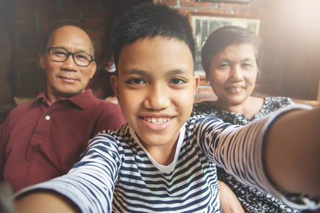 幸福的亚洲家庭微笑并考虑自拍照