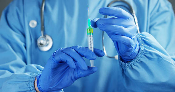 医生或科学家在举行一个注射器含有液体疫苗为儿童或老年人，或者治疗动物疾病的实验室。概念 疾病 医疗 科学 麻醉 安乐死