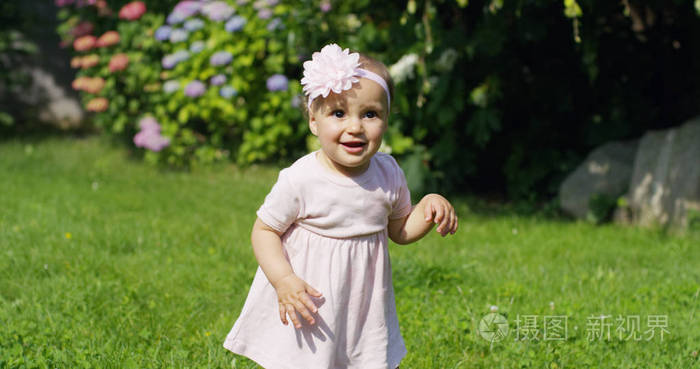投标的新生婴儿女孩想要的第一步在花园里阳光明媚的日子打扮一朵粉红色的宝宝舞者穿着对她头好表达有趣宝宝的乐趣舞蹈学校概念