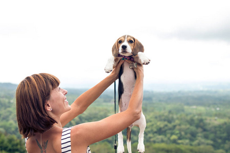 年轻女子捧着她的小犬在热带巴厘岛，印度尼西亚的性质