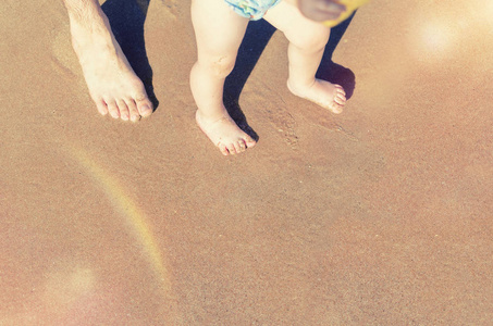 宝贝做他在海滩上的第一步