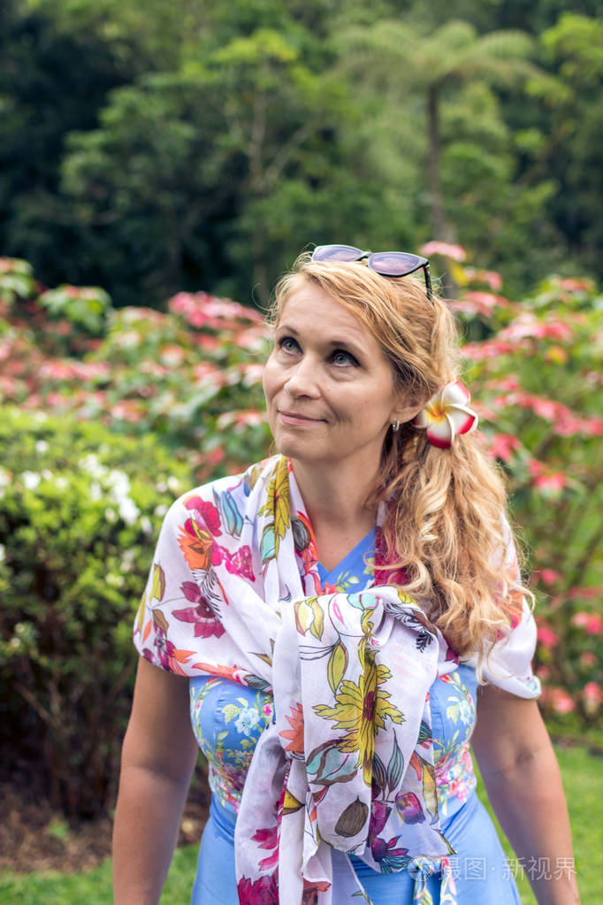 美丽的女人,在印度尼西亚巴厘岛上绽放亚洲花间构成的肖像