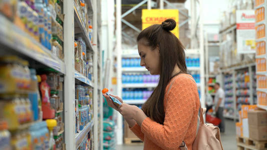 年轻的妈妈买婴儿食品在超市