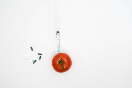 转基因生物概念与注射器 药片和 tomat 的白色背景上