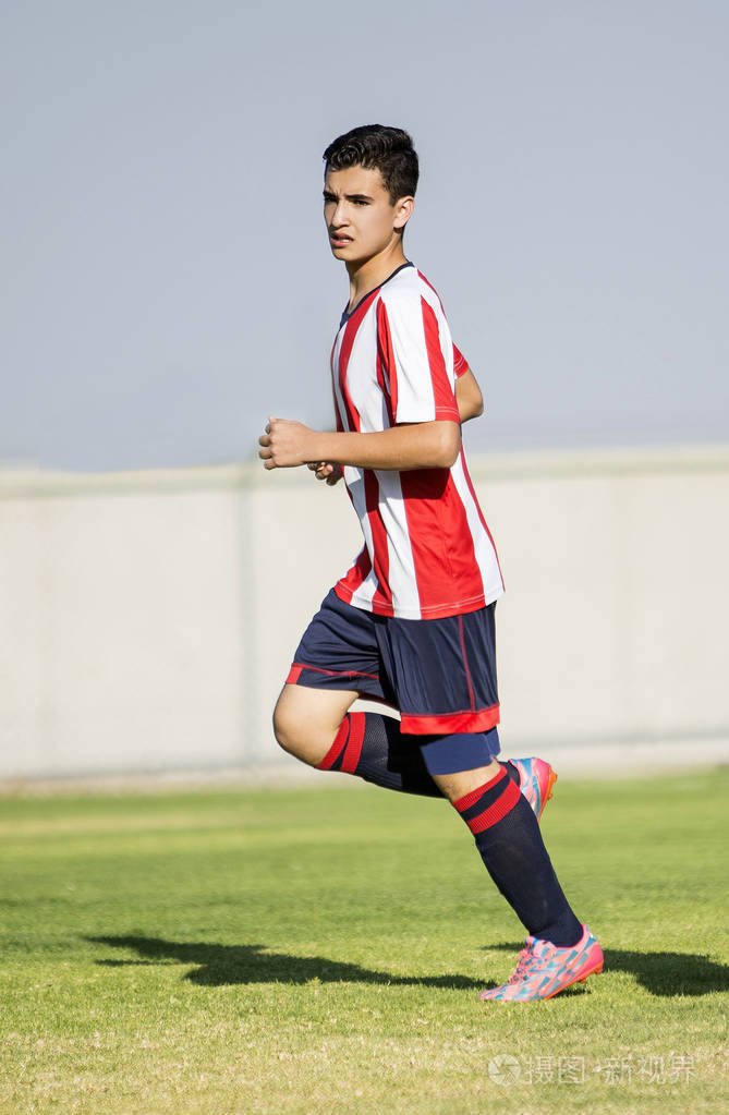 年轻的肌肉足球运动员在行动