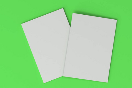 在绿色背景上的两个空白白色封闭的宣传册模拟