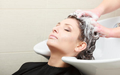 发型师给女人洗头。美发美容院