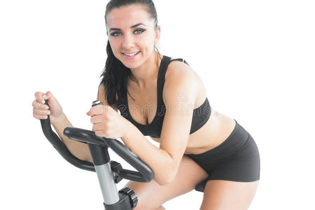 迷人的运动型女人骑着健身车锻炼