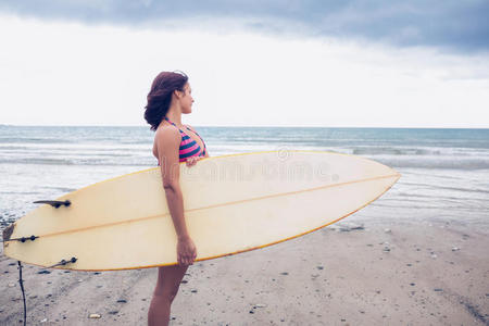 海滩上拿冲浪板的女人