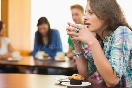 女性在咖啡店喝咖啡和松饼