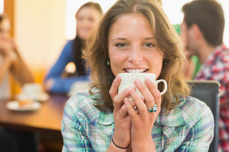 一位微笑的女性在咖啡馆喝咖啡的特写镜头