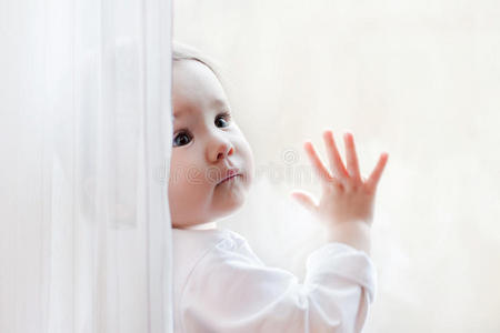 可爱的小女孩坐在窗前画像。