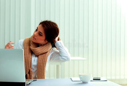 忧郁的女商人坐在自己的工作岗位上，望向别处