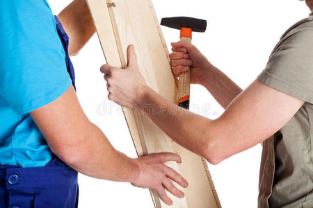 两个拿着木板和锤子的人