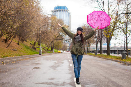 秋雨中撑伞散步的年轻女子图片