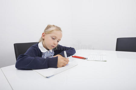 小女孩用毡尖笔在纸上画画图片