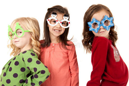 三个可爱的女孩戴着有趣的冬季眼镜，表情有趣