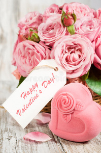 礼品盒形状的心和粉红色玫瑰与标签