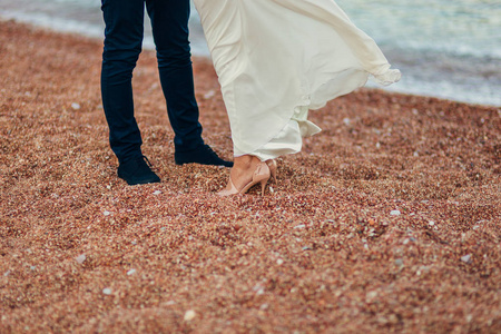 女装和男装的脚在沙子里