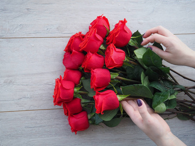礼品盒上的女人的手和美丽的玫瑰花束