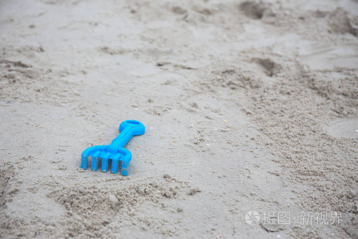 孤立在沙滩上的蓝色塑料砂施工玩具