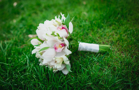 美丽惊人的白色兰花鲜花婚庆花束在绿色的草地上