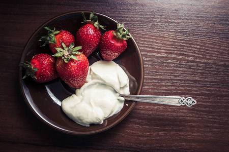 用勺子上一盘奶油草莓