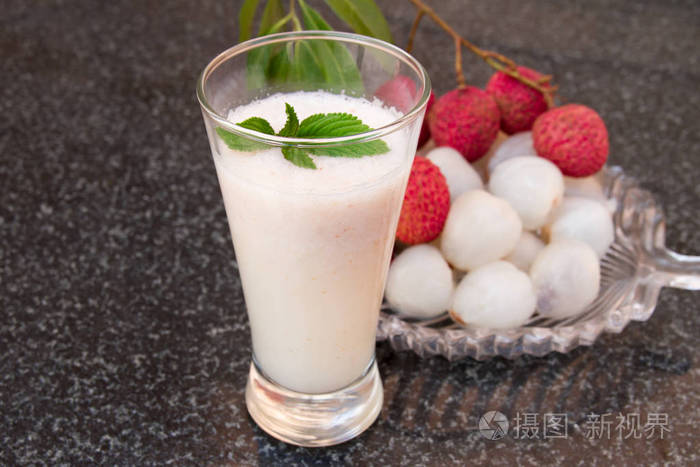 荔枝汁一杯.在一块玻璃板上新鲜多汁的荔枝水果