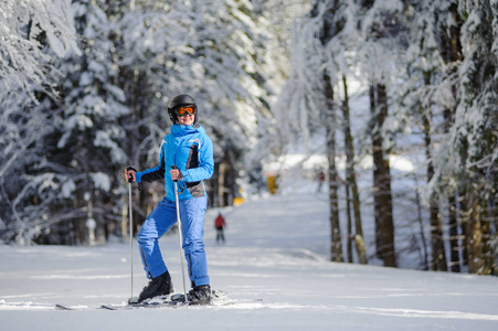 幸福的女人在森林里的滑雪斜坡上滑雪