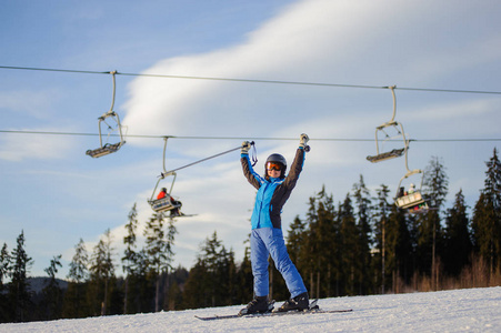 女子滑雪运动员对滑雪缆车和森林在阳光明媚的一天