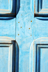 蓝色木门上的油漆和生锈的钉子