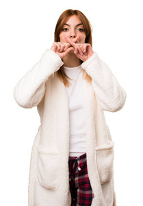 年轻女人穿着睡衣做沉默的手势图片