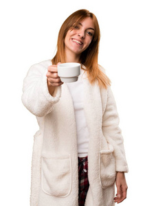 捧着一杯咖啡的晨衣的年轻女子