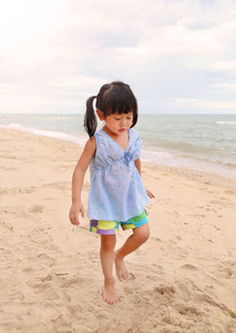 沙滩上的可爱的孩子女孩玩沙子