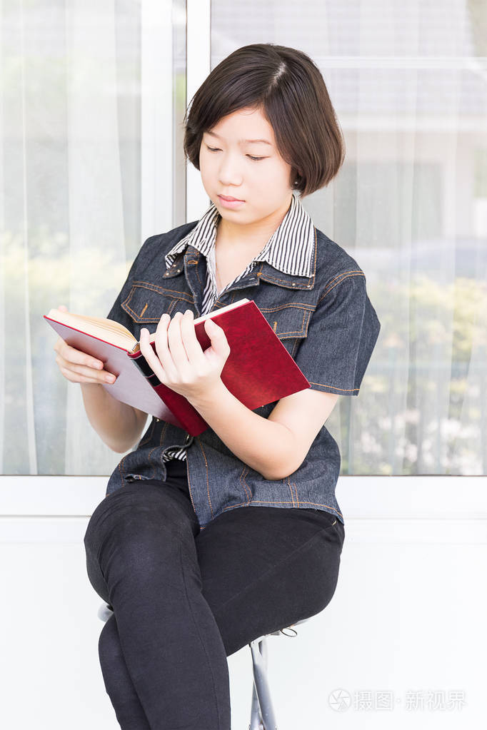 坐在椅子上读书的年轻女人